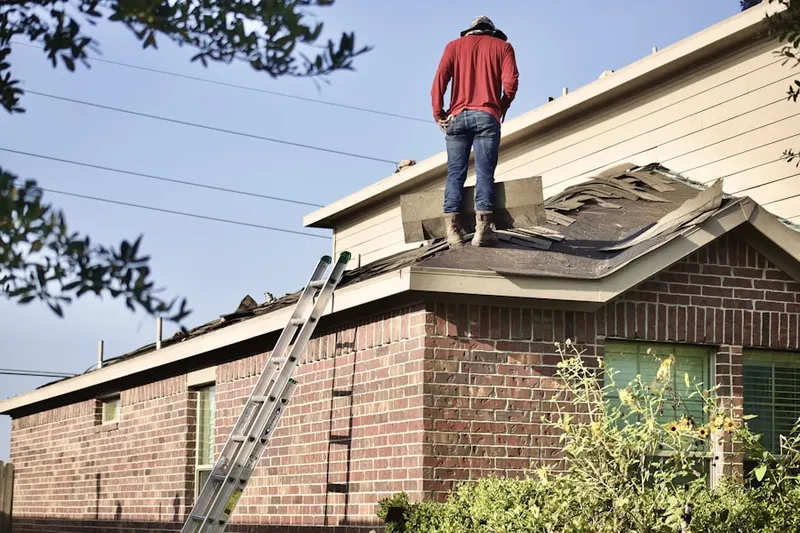 Professional roofer working on a residential roof in Stonington